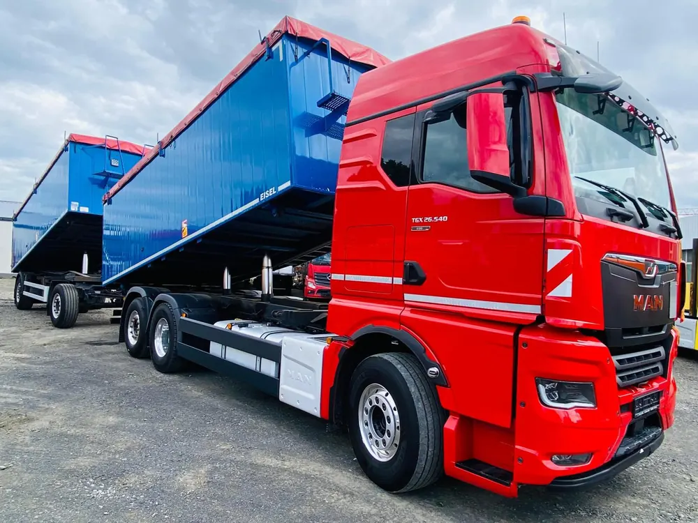 Roter MAN Lkw mit blauem Kippaufbau und Anhänger