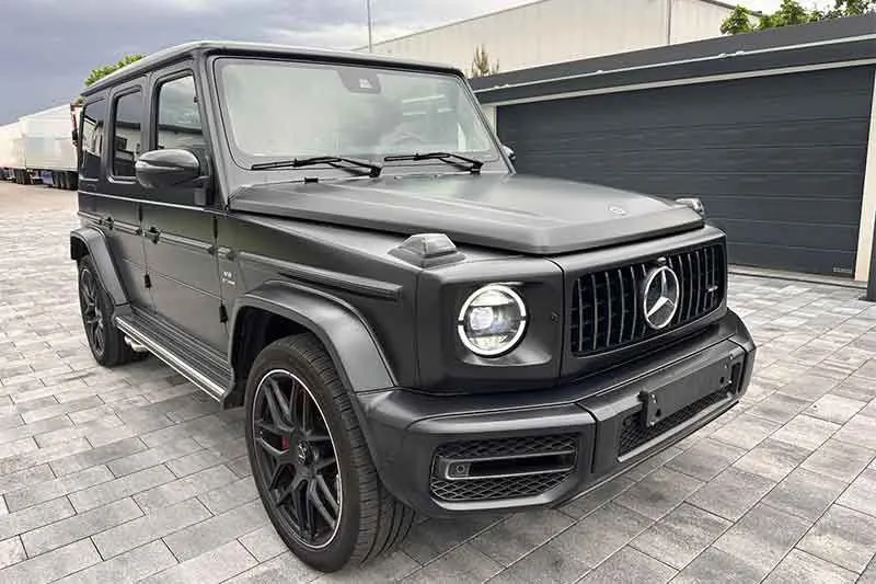 Schwarze Mercedes-AMG G-Klasse auf gepflastertem Hof
