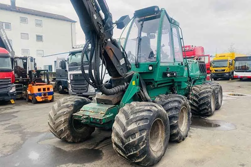 Grüner Harvester mit Kranarm auf dem Betriebsgelände