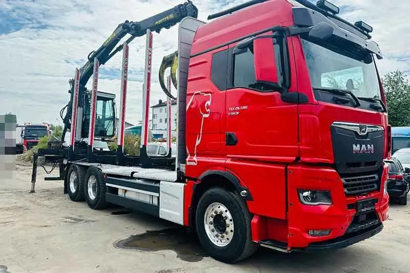 Roter MAN TGX Holztransporter mit Ladekran
