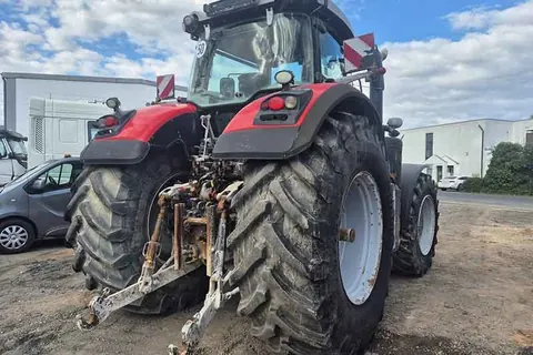 Roter Traktor mit Frontlader, schräg von hinten
