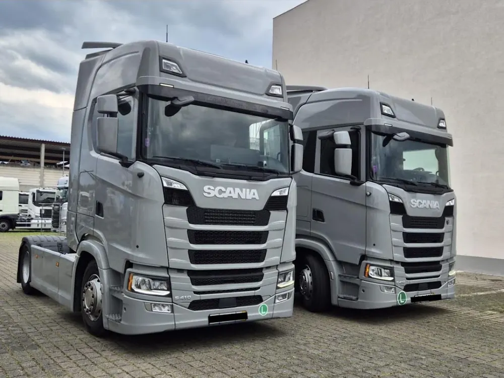 Zwei silberne Scania Sattelzugmaschinen nebeneinander